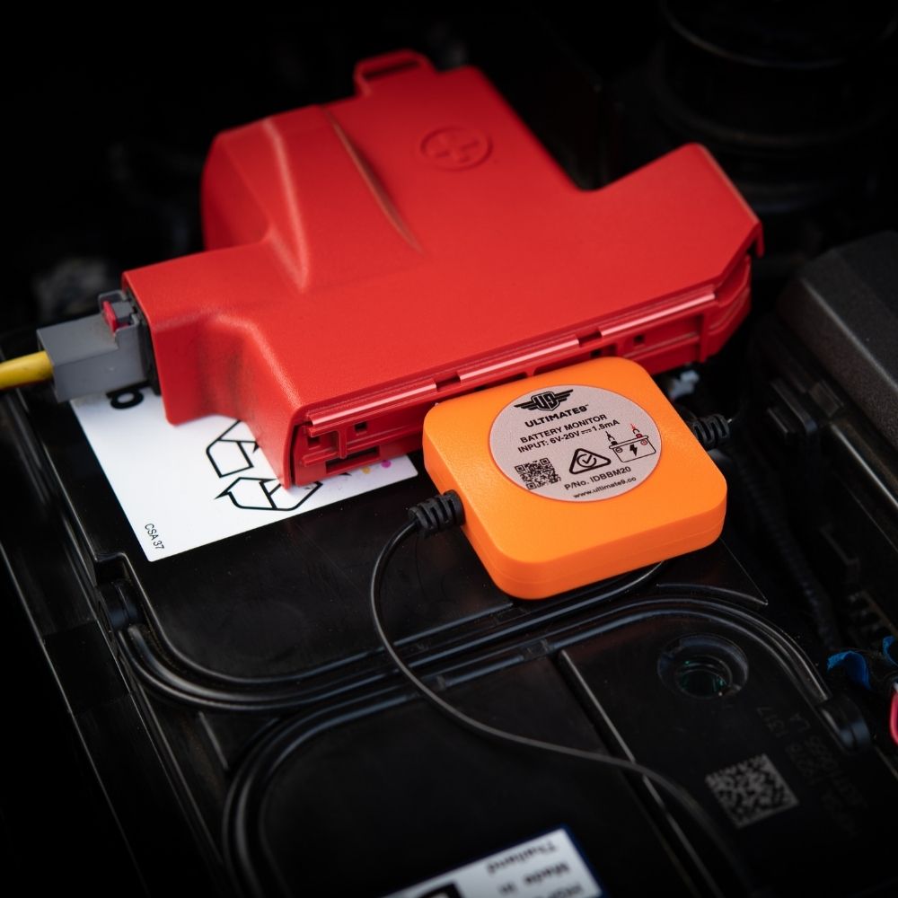 The Ultimate9 Bluetooth Battery Monitor installed on the positive and negative terminals of a 12V car battery.