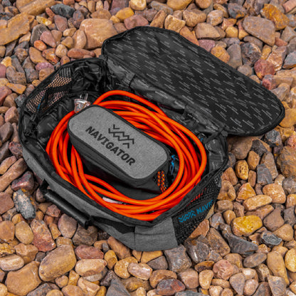 Navigator Utility Buddy unzipped showing coiled garden hose in main compartment and fittings in side pocket.